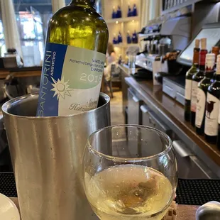 a glass of white wine and a bottle of wine