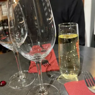 a man sitting at a table with wine glasses