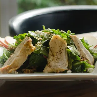 a plate of salad with chicken and spinach