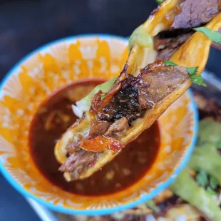 Smoked Brisket Birria Taco dipped in Consume