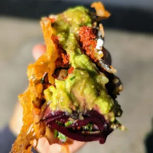 a hand holding a taco