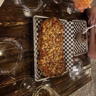 a table with a pizza and glasses of wine