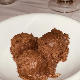 two scoops of chocolate ice cream on a white plate