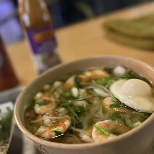 a bowl of soup with shrimp and vegetables