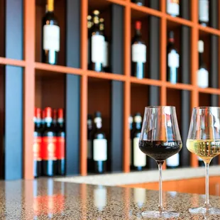 two glasses of wine on a bar