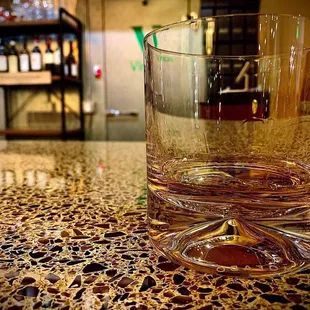 a glass of whiskey on a bar counter