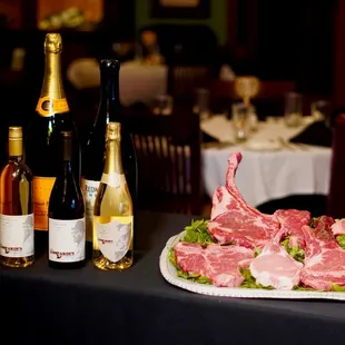 a platter of steaks and wine