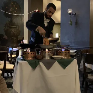 a man in a tuxedo serving food