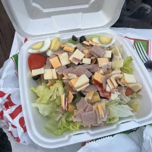 a salad in a styrofoam container