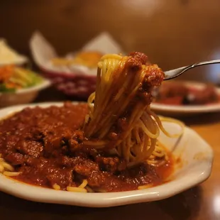 a plate of spaghetti being held by a fork
