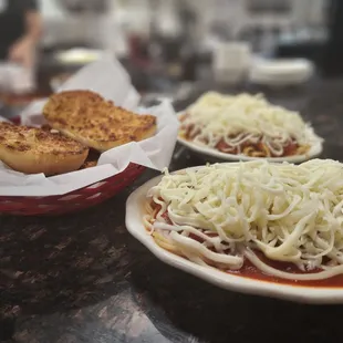 two plates of spaghetti and bread