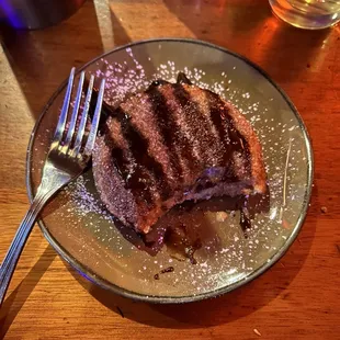 Fried uncrustable topped with sugar and finished with a drizzle of chocolate.