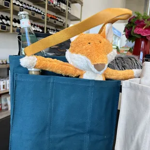 a stuffed fox in a blue bag