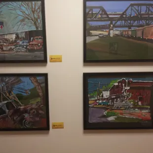 four framed paintings of a town