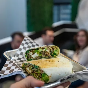 a person holding a burrito