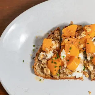 a piece of toast with oranges and cheese