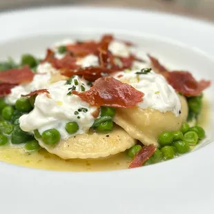 a plate of pasta with peas and bacon