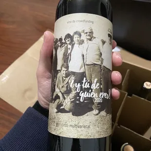 a hand holding a bottle of wine