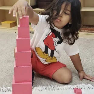 One of our Toddlers concentrating on ordering the pink cubes from largest to smallest.