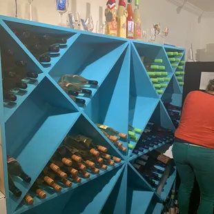 a woman looking at bottles of wine