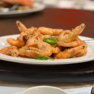 a plate of shrimp and a bowl of dipping sauce