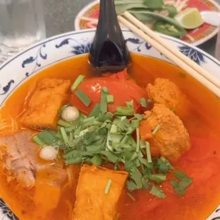 Bún Riêu - a tomato based soup broth with crab meatballs and tofu, vermicelli noodles .