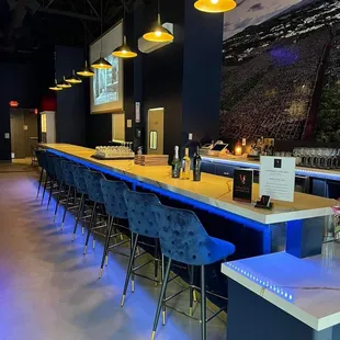 Long wine bar with screen and artwork.