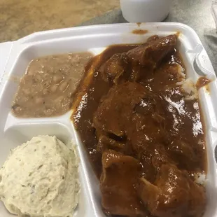 a plate of meat, mashed potatoes, and gravy