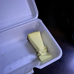 a piece of cheesecake in a styrofoam container
