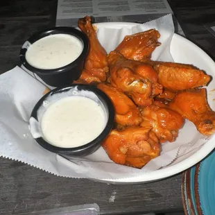 a plate of chicken wings with dipping sauce