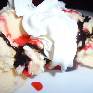 Vanilla ice cream with chocolate &amp; strawberry drizzle, close-up.