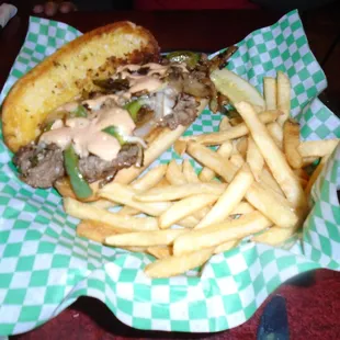 Philly cheesesteak sandwich with fries.