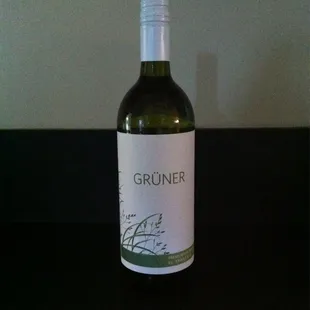 a bottle of gruner wine on a table