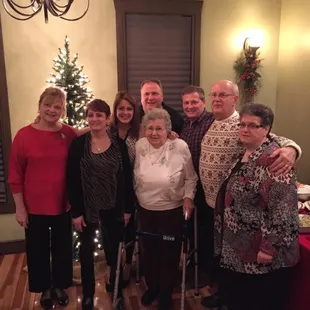 a group of people standing in front of a christmas tree