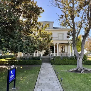 the front of a house with a sign in front of it