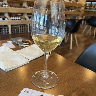 a glass of white wine on a table