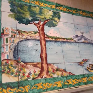 a painting of a tree on a tiled wall