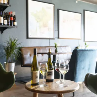 two wine glasses and a bottle on a table