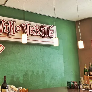 a green wall with a sign that says vino verite