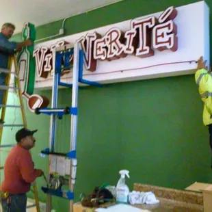 Construction, summer 2015.  Putting up the old sign inside behind the tasting bar.