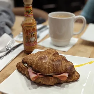 a croissant sandwich with ham and cheese