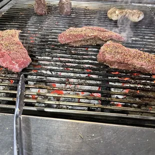 steaks cooking on a grill