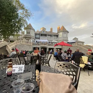 a group of people sitting at tables outside