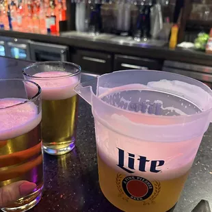 two glasses of beer on a bar