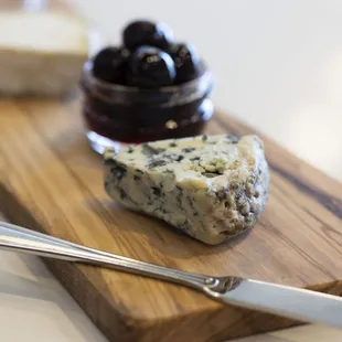 cheese and olives on a wooden board