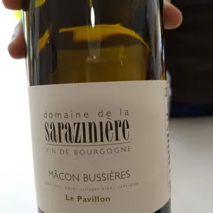 a hand holding a bottle of wine