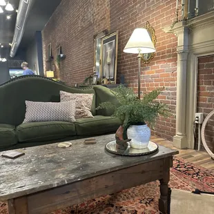 a living room with a green couch and a fireplace