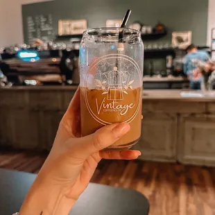 a hand holding a glass of coffee