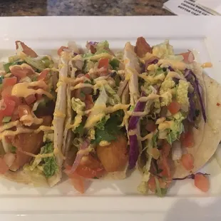 three tacos on a white plate