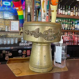 a bar with a gold vase with candles on it